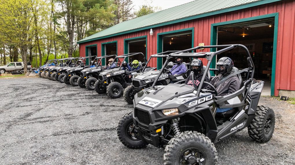 rzrs parked in front a barn