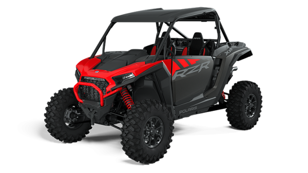 Red and black off-road vehicle with roll cage and large tires.