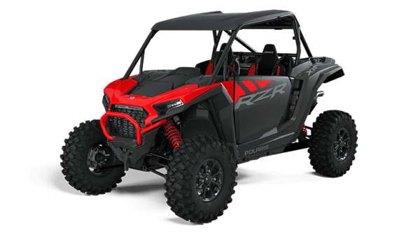 Red and black off-road vehicle with roll cage and large tires.