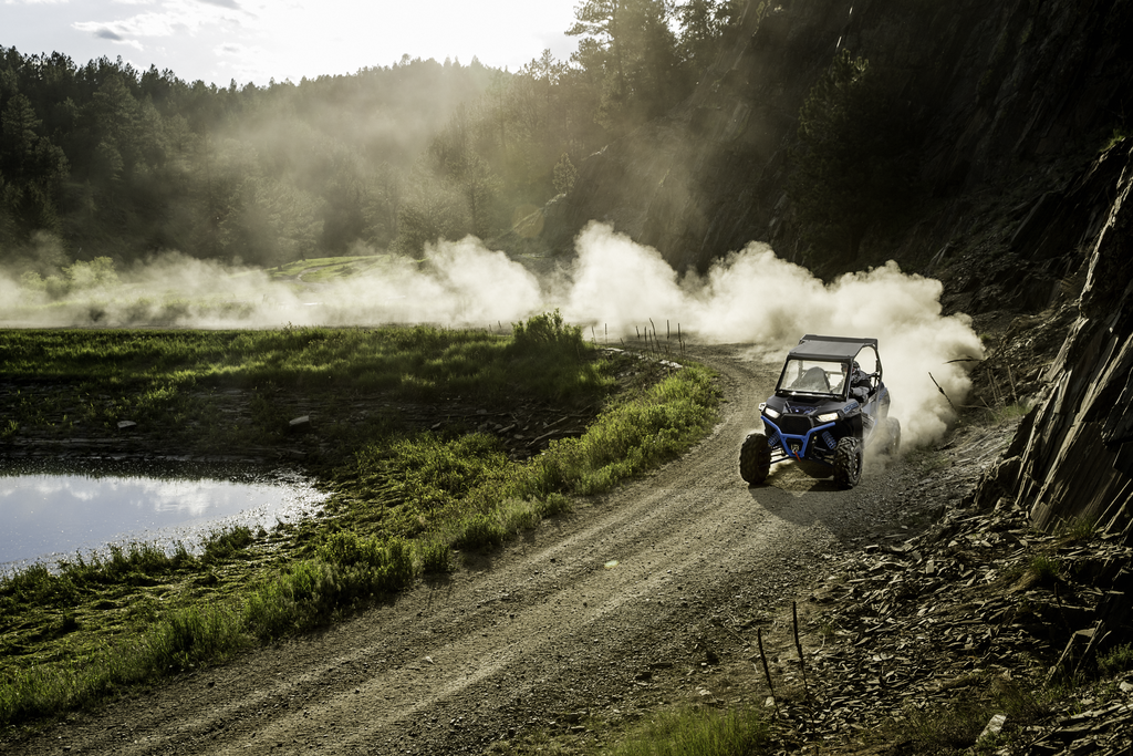 a person riding an ATV on a track with smoke coming out of it